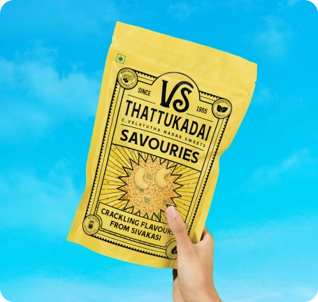 VS Thattukadai snack packs with bowls of mixture and thattai on a red tabletop